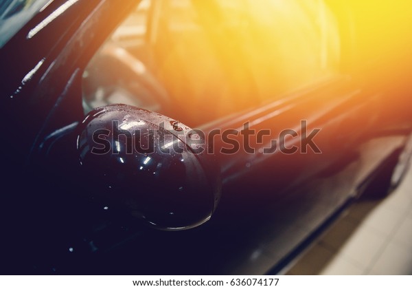 Master installs a tint film for the car\
glass with a hairdryer and spatula with glare of light. Concept\
tinting car. Toning and\
highlighting.