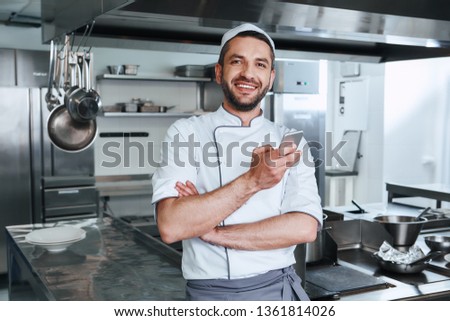 The master of kitchen. Happy chef cook standing in commerical kitchen
