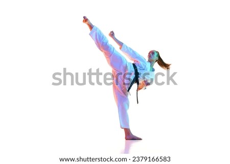 Master of Kung Fu, fighter show high kick pose in neon light, filter against over white background. Concept of sport, recreation, art, hobby, culture. Copy space for ad, text.