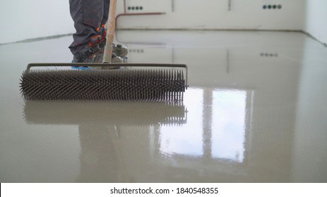 Master With A Needle Roller. Filling The Floor. A Contractor Painter Will Paint The Garage Floor To Speed Up The Sale Of Your Home. Floor Screed Filling, Repair And Finishing. Fill In The Low Spots