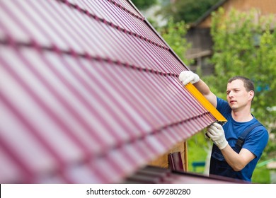 master on repair of roofs makes measurements tool - Shutterstock ID 609280280