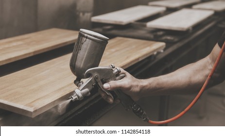 Master Painter In A Factory Painting Wood With Spray Gun.