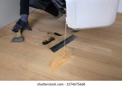 Master Parquet With Glue Bin In Your Hand. Preparation Of Parquet Grout Material. Mixing Retainer, Varnish And A Small Mixture Of Wood. Pre-varnishing Phase