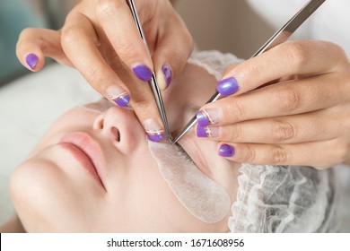 master is performing procedure of lash extension on female eyelids - Shutterstock ID 1671608956