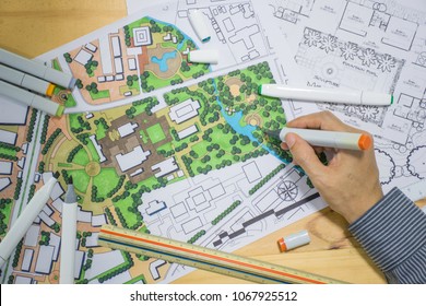 Master Plan Of Urban Landscape Design Or Urban Architecture Drawing By Man's Hand With Drawing Tools , Color Markers, Scale Rulers On The Table, Selective Focus  