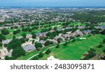 Master planned community and urban sprawl lush greenery area with downtown Plano Texas background, golf course community, row of large two-story mansion homes swimming pool, Dallas, aerial view. USA