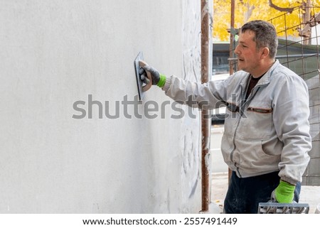 A master plastering a walls. The process of applying plaster on the wall. The concept of renovation and redevelopment of the house