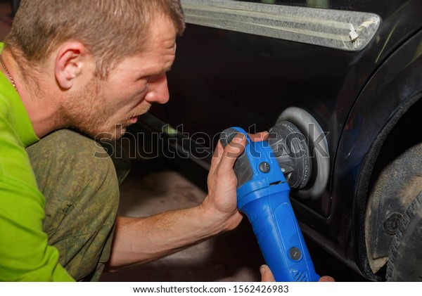 The master polishes the machine with a grinder with\
paste. Car care.
