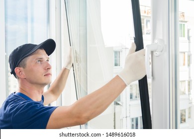 master puts a new double-glazed window in a plastic window - Shutterstock ID 1489616018