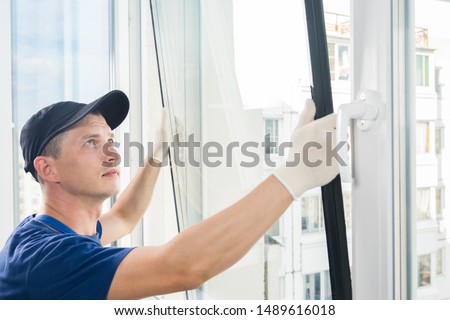 master puts a new double-glazed window in a plastic window