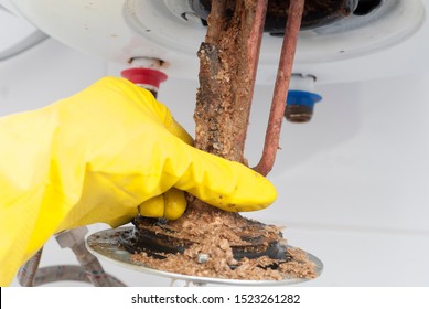 Master Removes An Old Electric Heater From A Water Tank