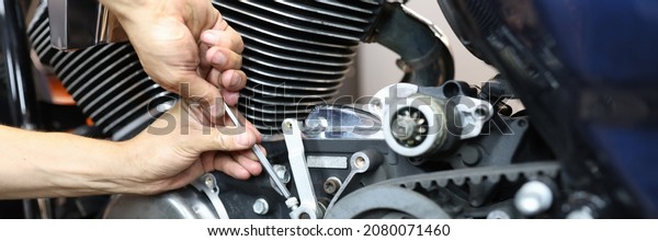 Master repairman\
repairing motorcycle in workshop closeup. Repair and maintenance of\
motorcycles concept