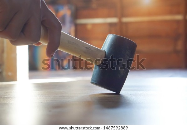 Master rubber mallet knocks on the laminate in the\
process of laying