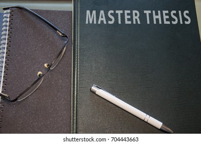 A Master Thesis Hard Cover, Notepad Pen And Glasses