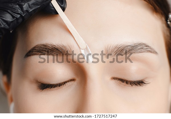 Master wax depilation of eyebrow hair in\
women, brow correction.