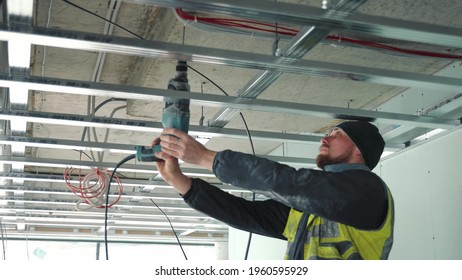 A master who drills a hole in the ceiling with a drill. Creation of false ceilings.