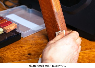 Master Wipes A Scratch On A Leg From Wooden Furniture Restoration Repair Close-up.