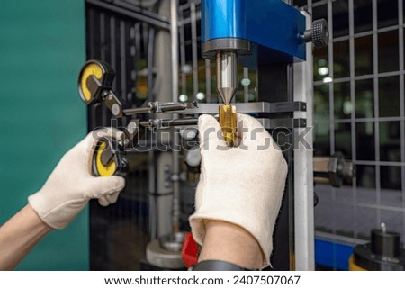 The master worker checks the CNC cutting tool for runout at the centers.