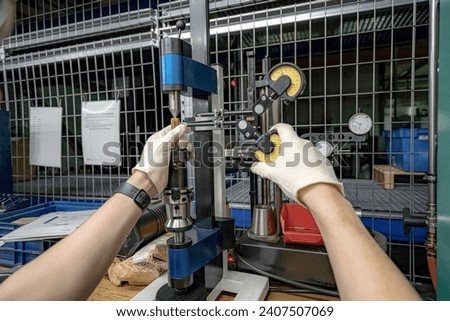 The master worker checks the CNC cutting tool at the centers for runout using indicators.