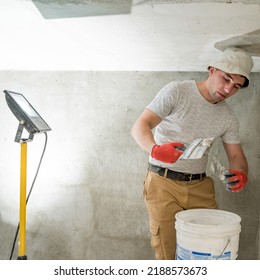The master works with lime plaster, leveling the wall with a spatula and lime plaster, repairing work on leveling the walls. - Shutterstock ID 2188573673