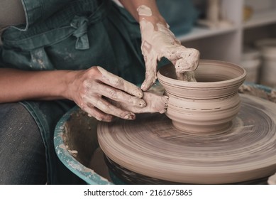 Master works on potter's wheel, doing blank. Hands of person sculpt pot from white clay. Workshop for manufacturing potter's products. Concept: handmade, workshop, artist - Powered by Shutterstock