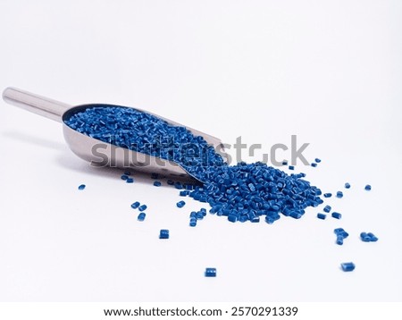 Masterbatch plastic, polymer granules carrying blue masterbatch pigment poured into a white background, suitable for product catalog photography design for industrial plastic company profiles