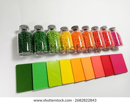 Masterbatch variations in glass bottles with chips, polymer carrying pigment isolated on a white background, suitable for product catalog design of industrial plastic company profiles, space available