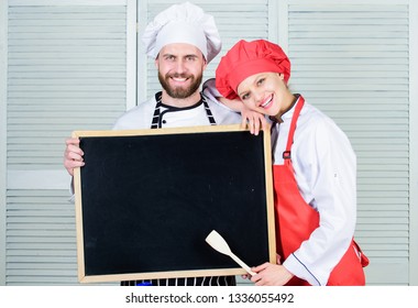 Mastering cooking skills. Couple of man and woman holding empty blackboard in cooking school. Master cook and prep cook giving cooking class. Chef and cook helper teaching master class, copy space. - Powered by Shutterstock