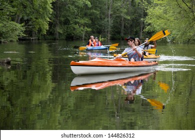 MASURIA, POLAND - JULY 13: Unidentified People Take Kayak Trip On Krutynia River On July 13, 2012 In Masurian Ditrict, Poalnd. More Than 5 Million Tourists Visit Masuria Every Year.