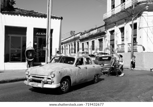 MATANZAS, CUBA - FEBRUARY 23, 2011: Man drives old\
American car on February 23, 2011 in Matanzas, Cuba. New change in\
law allows Cubans to trade cars. Cars in Cuba are very old because\
of the old law.