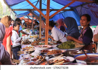 MATARAM, INDONESIA - July 13, 2013: People in asian wet market selling traditional Indonesian dishes in the streets. It is during puasa, before Ramadan, when people buy food during the day