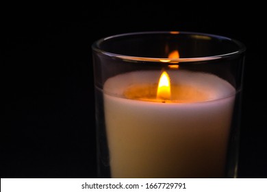 A Match In Hand Ignites A Candle In A Glass Jar. Sadness, Remembrance And Condolence Concept