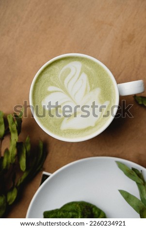 
Matcha green tea, closeup, flowers and magazine, pattern on tea and coffee, green drink in a cafe