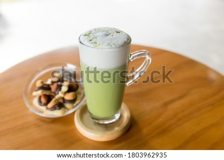 Matcha green tea latte beverage in glass mug with whisk. Matcha green tea latte beverage in glass mug.  Matcha Smoothie. This smoothie is made with powdered green tea