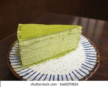 matcha green tea mille crepe cake with vanilla whipped cream on a japanese style plate close up with warm wood background - Powered by Shutterstock