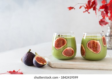 Matcha green vegan smoothie with chia seeds and figs in glasses on white background. Autumn detox recipe, superfoods, healthy eating. Japanese green matcha tea. Side view, copy space for text