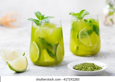 Matcha ice green tea with lime and fresh mint on a marble background. Close up.