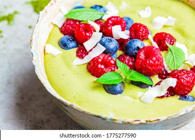 Matcha Tea Green Smoothie Bowl With Berries And Coconut, Gray Background.