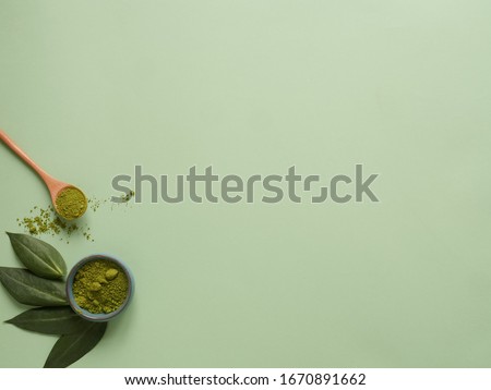 matcha tea with spoon and leaf on grean background. Concept healthy drink, copyspace, flatlay, top view.