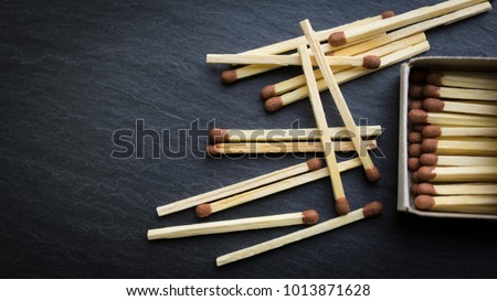 Matches in box, dark background. Macro photography. Close-up shot. Matches in open match-box on carton underlay. 