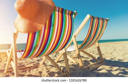 Matcheswooden chaise longue chairs on beach - Powered by Shutterstock