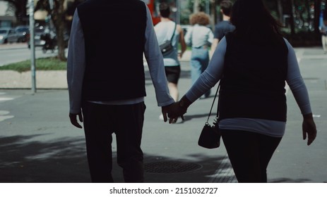 Matching Couple Holding Hands In A Big City