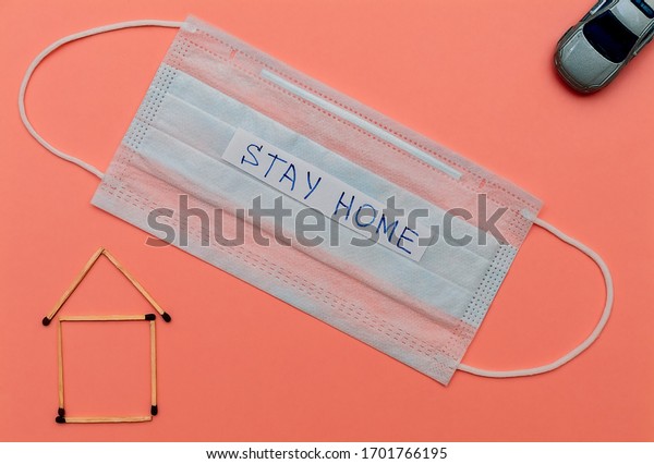 Matchstick house, car\
and medical face mask with text stay home on pink background.\
Medical concept. Self-isolation, quarantine, pandemic, coronavirus.\
Flat lay, copy\
space.
