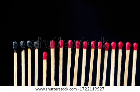 matchsticks burnt in row as sequence while one match stay down from burning to avoid fire connecting against black background, social stop pandemic concept.
