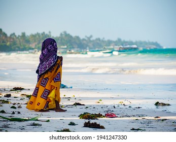 Matemwe, Zanzibar - Jan, 2021: African girl on the sandy beach. The daily life of the local people of Zanzibar. Tanzania, Africa