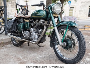 Matera, Italy - 3 September 2019: Historic British motorcycle Royal Enfield green colour parked in a street in the city of Matera, front side view.