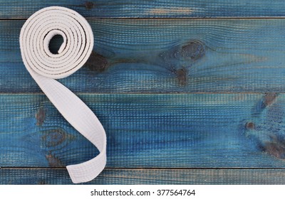 Material art background. Karate, Judo, TaeKwonDo belt on wooden table
