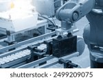 The material handling process by robotic arm in battery production line. The high technology material handling process by robotic system.