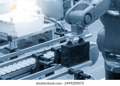 The material handling process by robotic arm in battery production line. The high technology material handling process by robotic system.