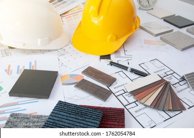 Materials construction. Home materials for Engineer and architec. Safety helmet on work table. Home budget and plan with materials design. Sample of wood laminate and carpet.